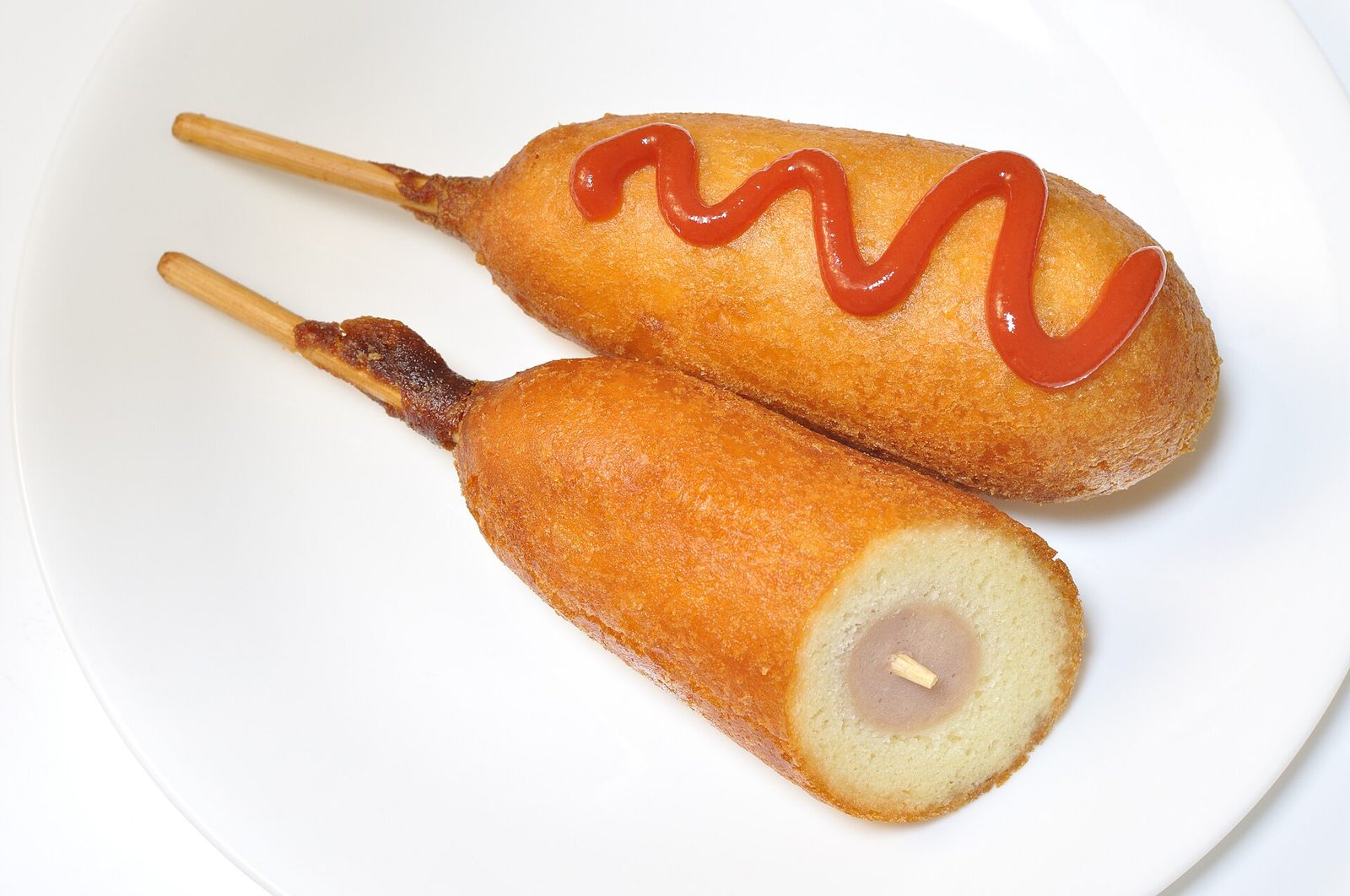 Two corn dogs on a plate, the signature item among the best food and rides at State Fair of Texas