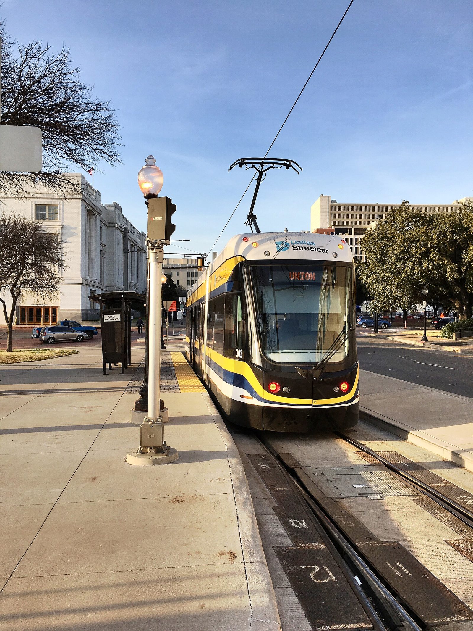 A modern Dallas Streetcar vehicle stopped beside Union Station downtown