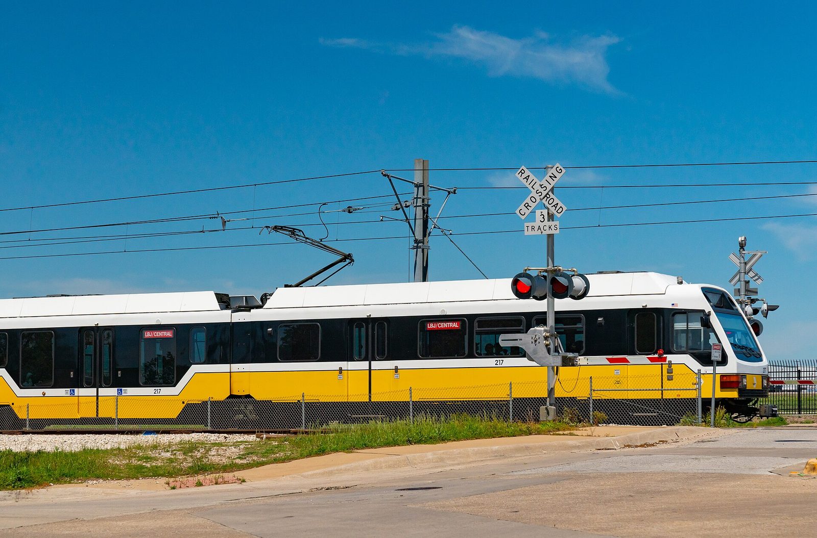 A yellow and white DART light rail train in Dallas, the backbone of any accessible Dallas travel guide