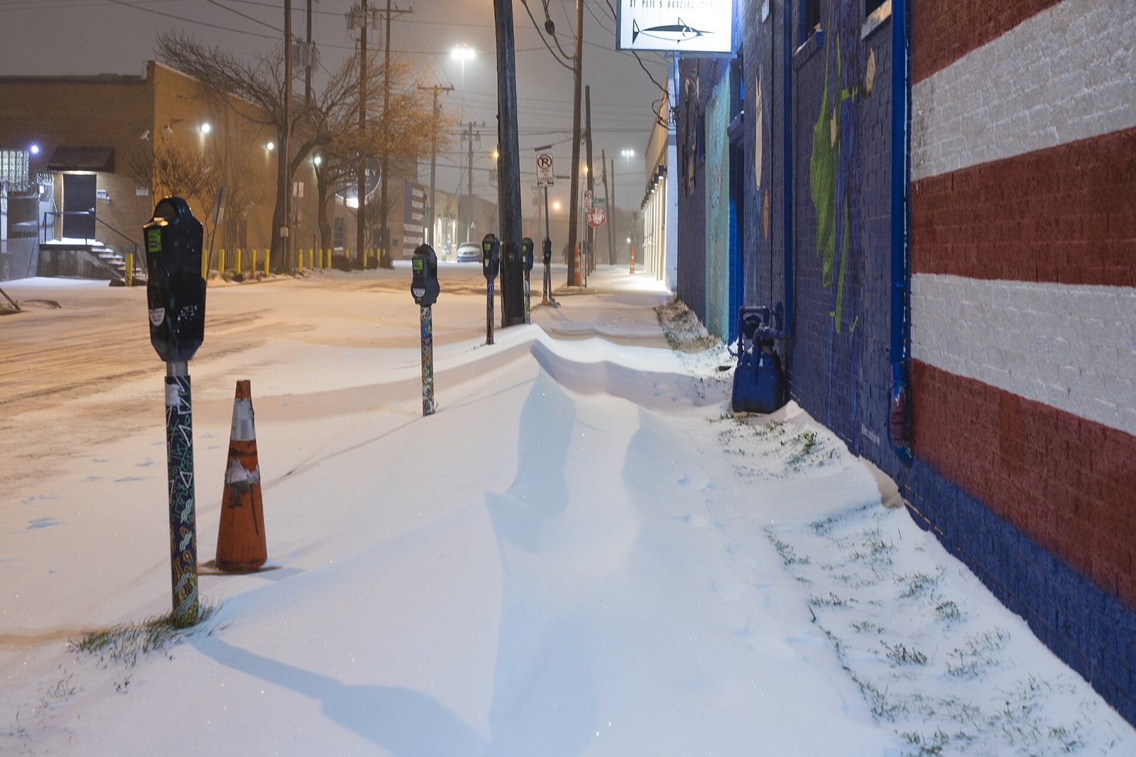 A Deep Ellum sidewalk in Dallas covered in snow during a winter storm