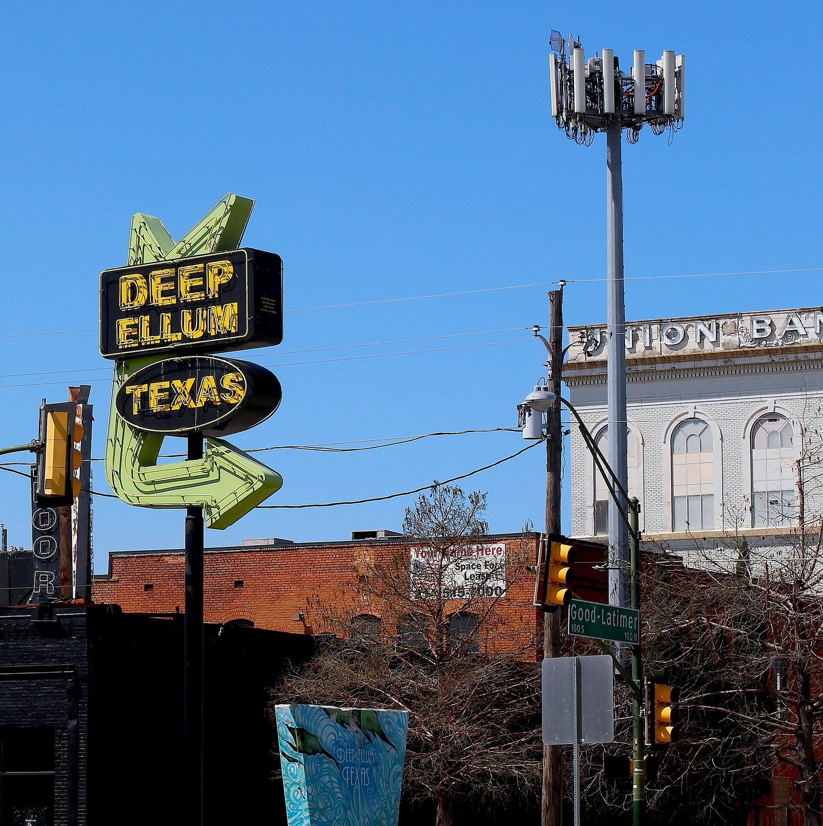 The neon Deep Ellum sign over a street of bars and music venues in Dallas