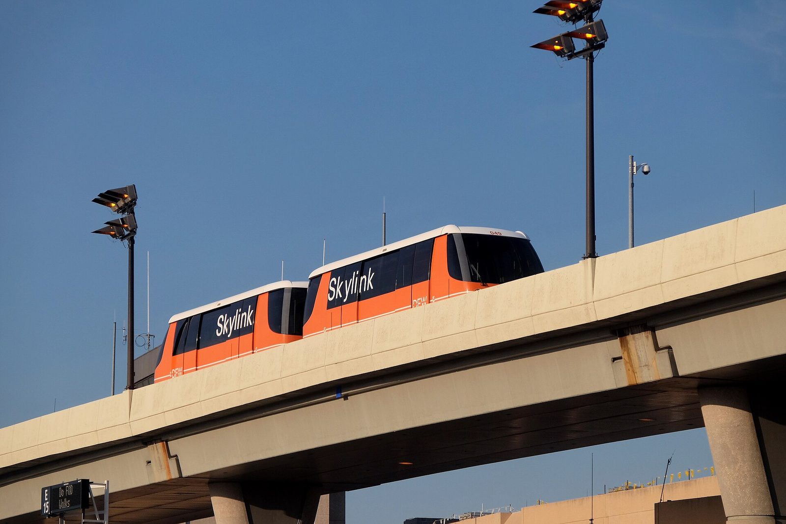 A Skylink automated people mover train on its elevated guideway at DFW Airport