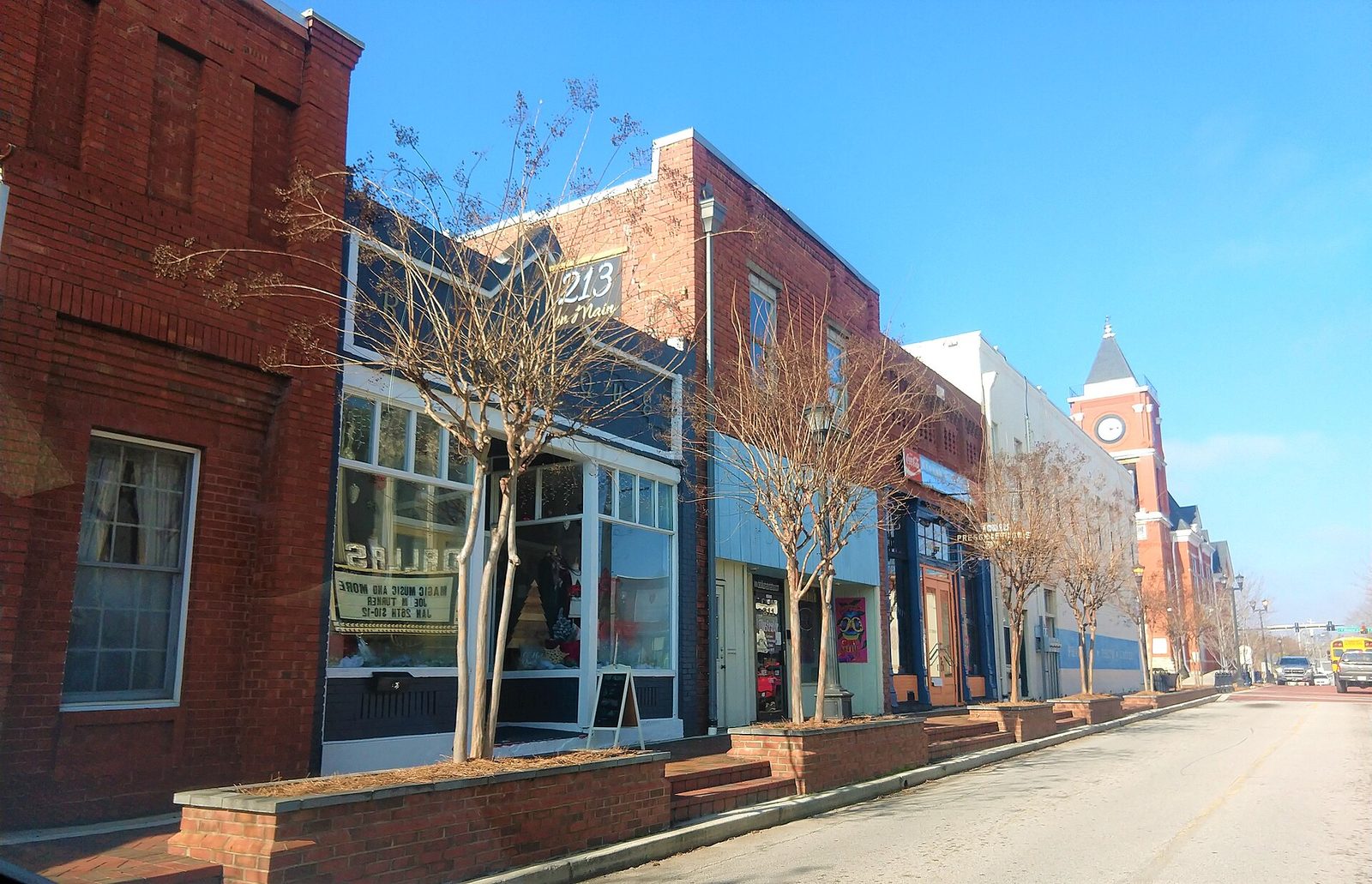Downtown Dallas street of low brick buildings with the towers rising behind