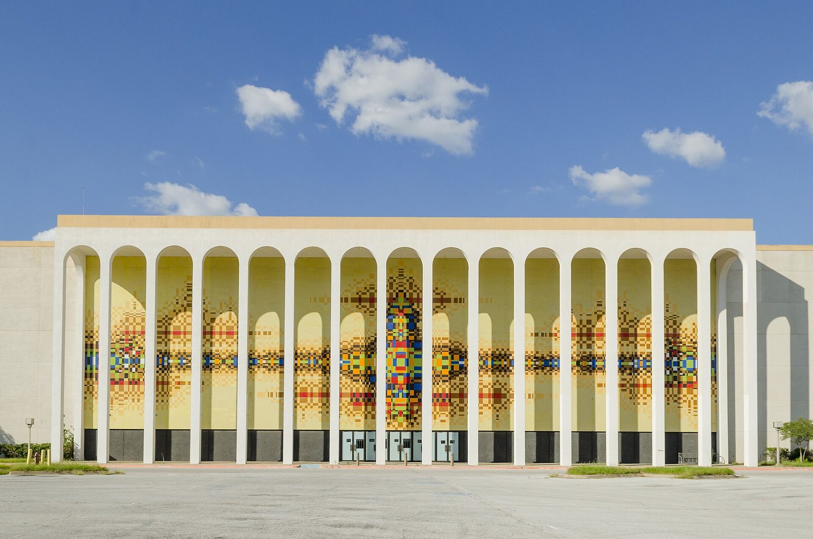 A long colonnaded Fair Park building in Dallas with a brightly coloured mosaic façade