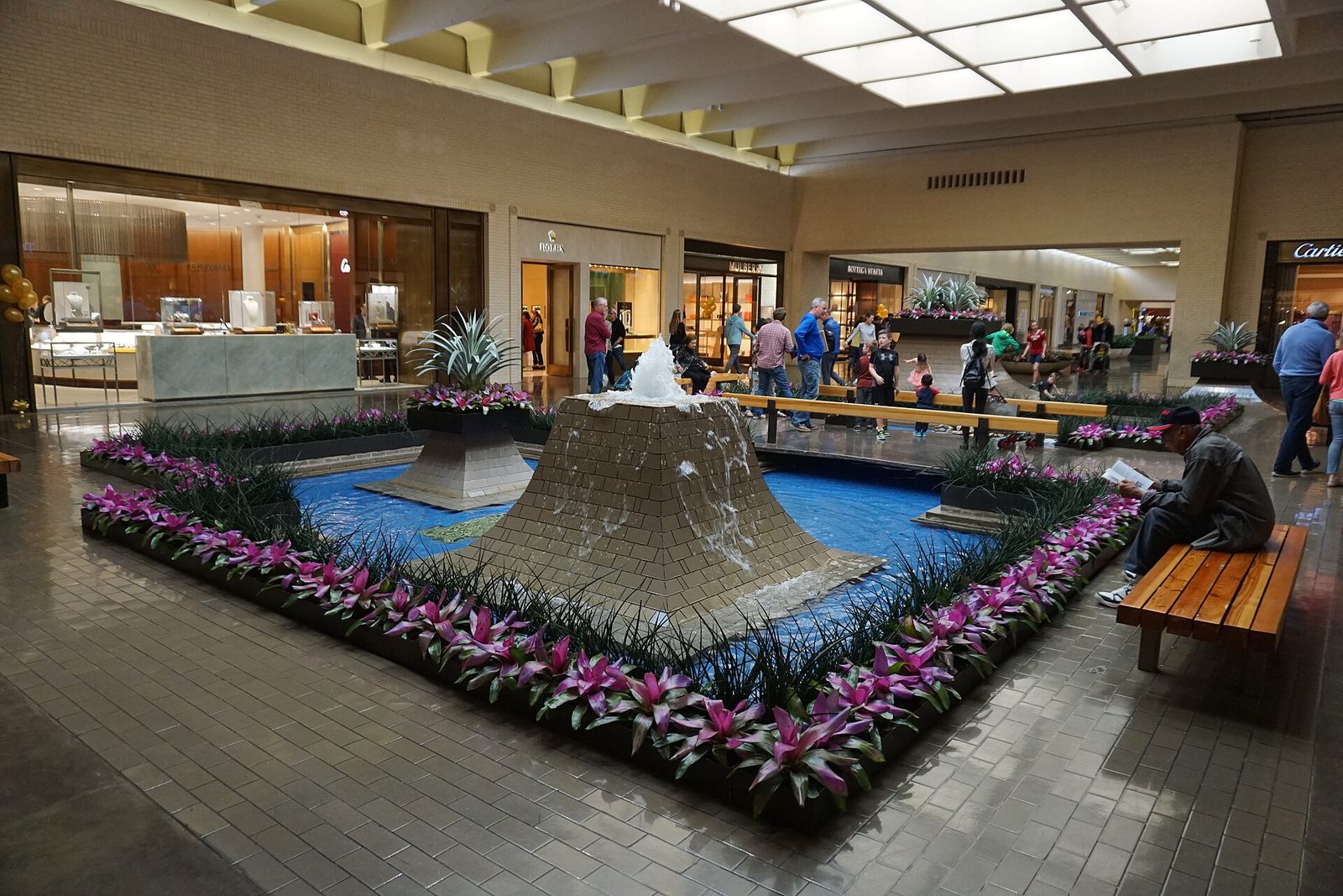 The interior of NorthPark Center in Dallas with a fountain and planted beds