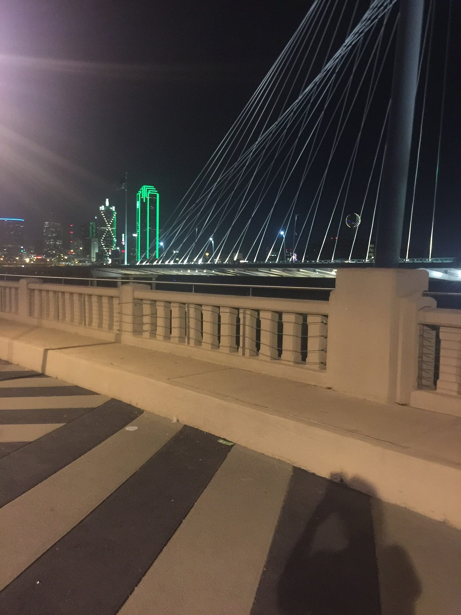 The Ronald Kirk Bridge lit at night with the green-outlined Dallas skyline beyond, one of the free things to do in Dallas at night