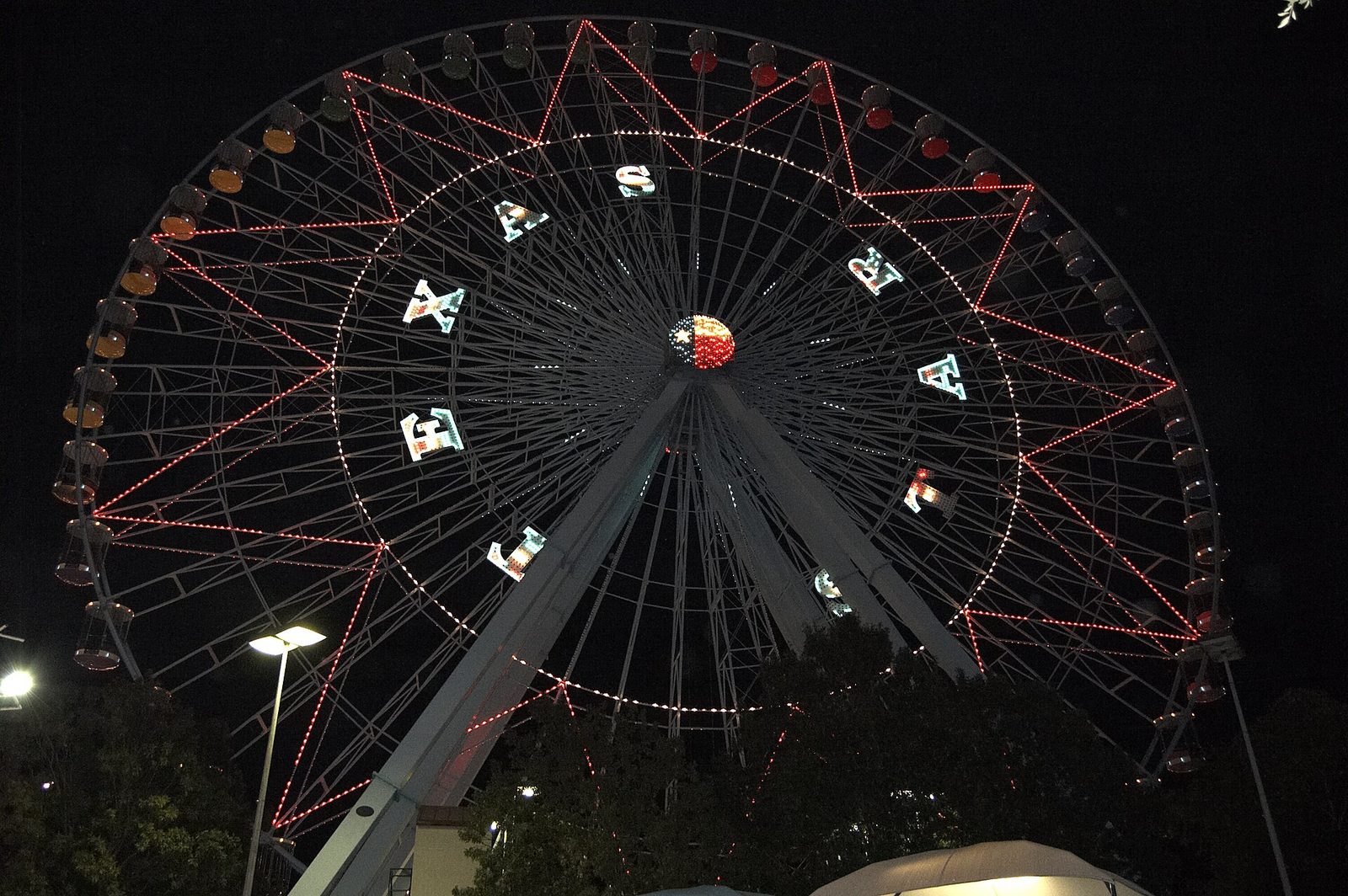 The Texas Star ferris wheel lit at night with its name spelled out in lights