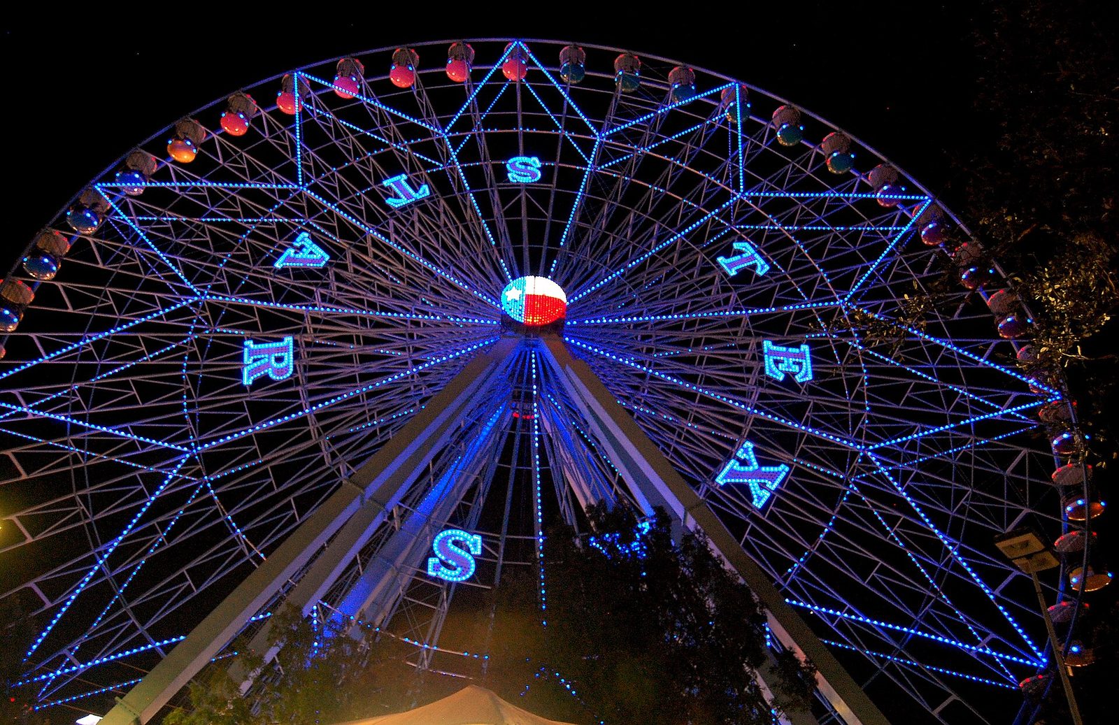 The Texas Star ferris wheel lit in blue and red at night at Fair Park in Dallas