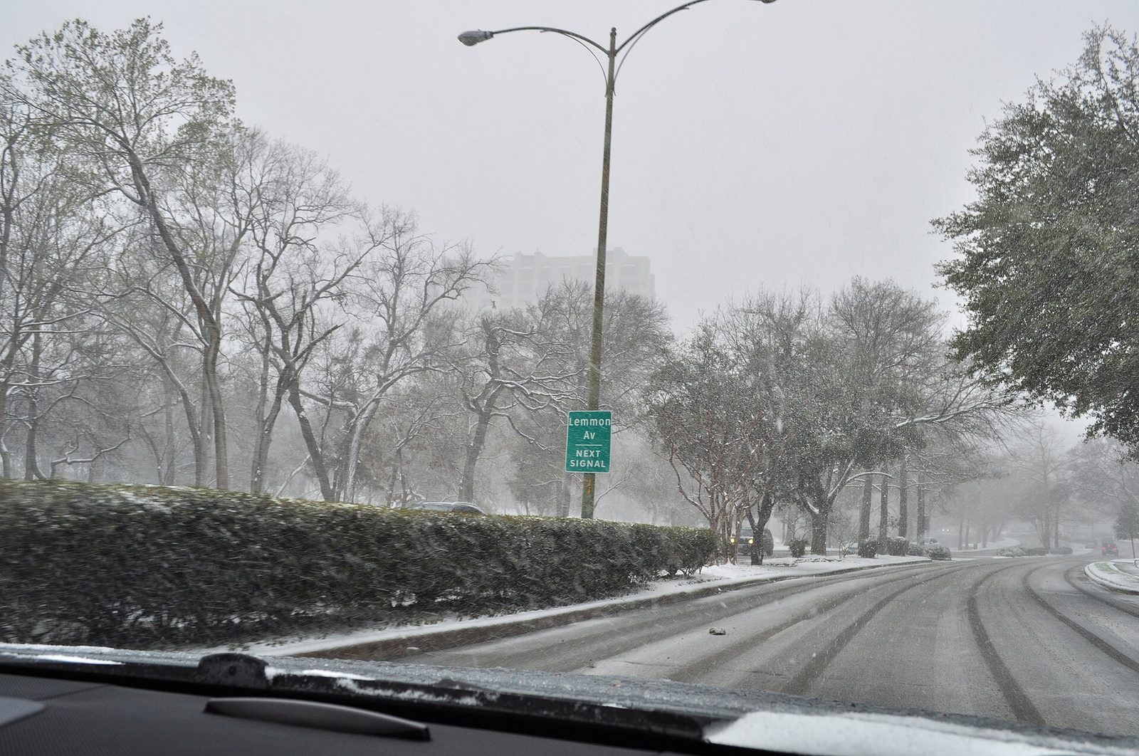 Turtle Creek in Dallas under snow, with bare trees along an icy road